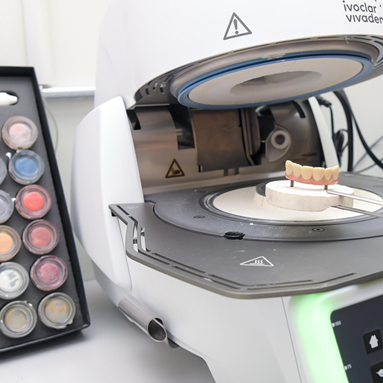 Machine in dental laboratory crafting a denture