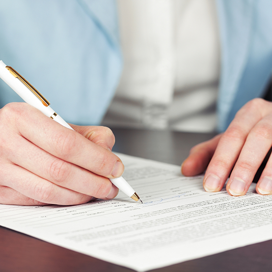 Person filling out paperwork at a desk