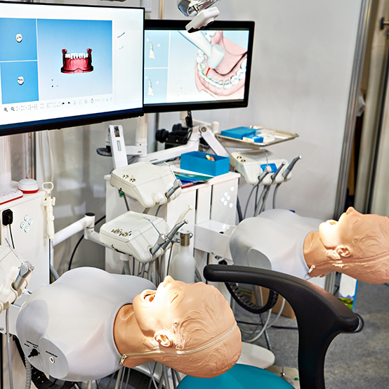 Two robots resembling dental patients at a dental school