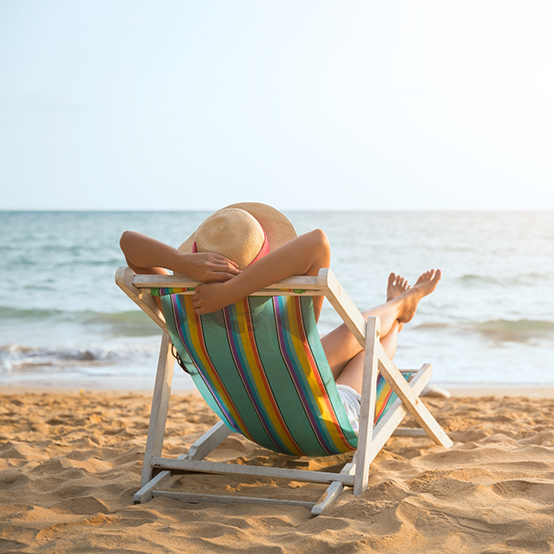 Person relaxing in a lawn chair on the beach